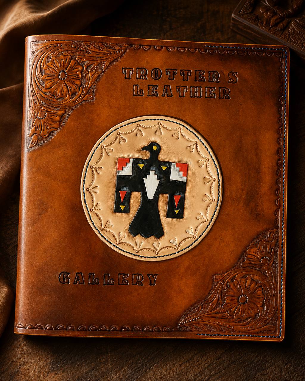 Tooled Trotter's Leather gallery cover with thunderbird design.
